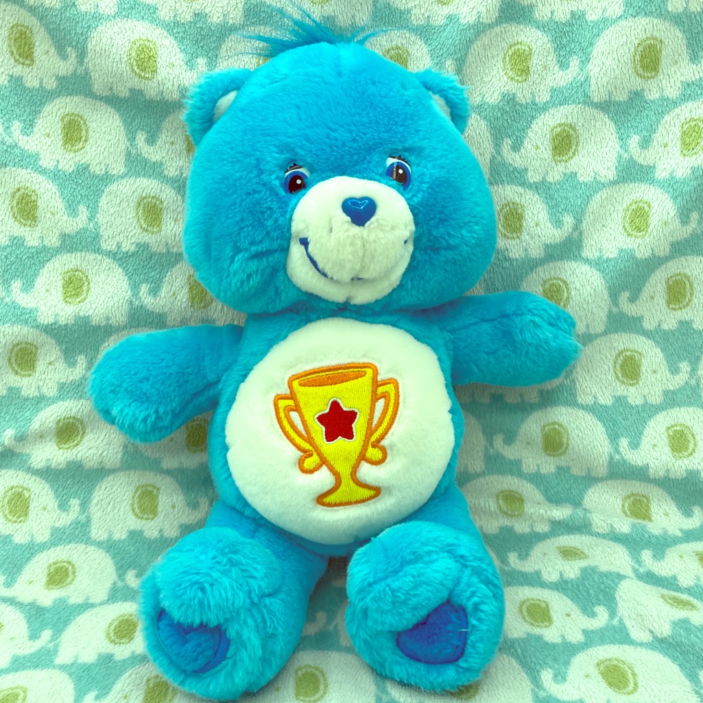 Care Bears Champ Bear plush with a trophy belly badge, listed by a US resale seller